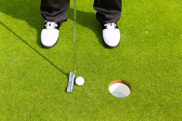 Golf játékos golyó lyukba - Fotó, kép