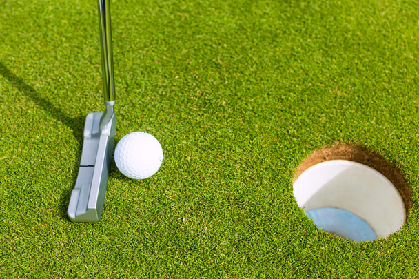 Jugador de golf poniendo pelota en el agujero
 - Foto, Imagen