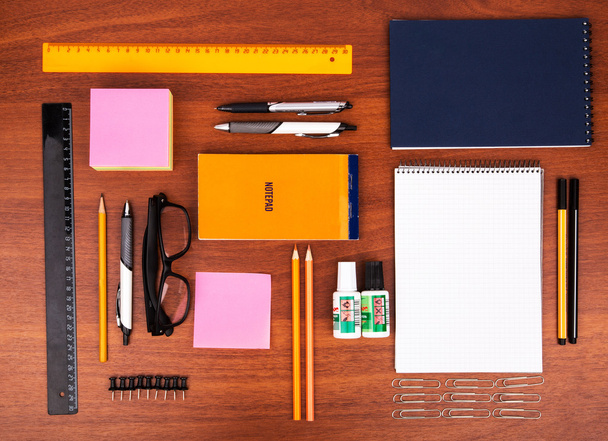 Bureau met glazen pen potlood liniaal en andere kantoorartikelen - Foto, afbeelding