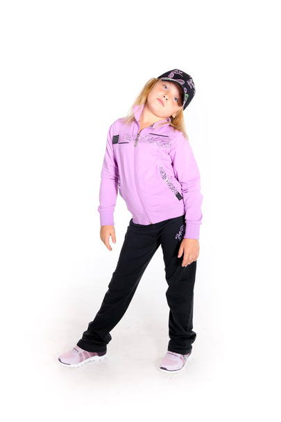fiatal lány sport felszerelés és egy sárkánymintás póló, pózol a fehér stúdió - Fotó, kép
