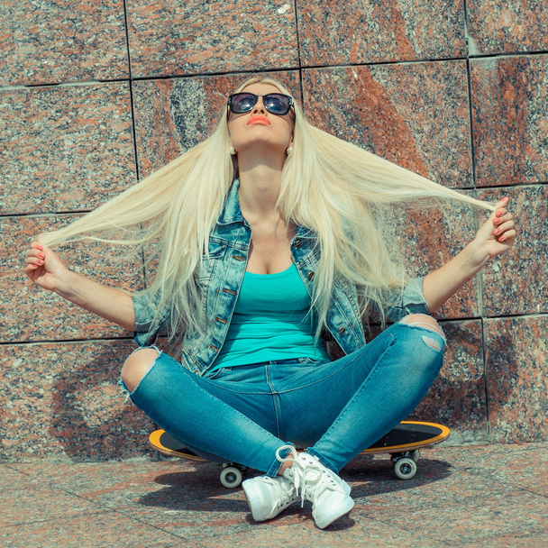 Girl sitting on a skateboard - Photo, Image