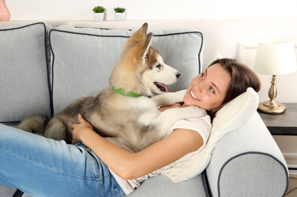 Woman lying with her malamute dog - Foto, afbeelding