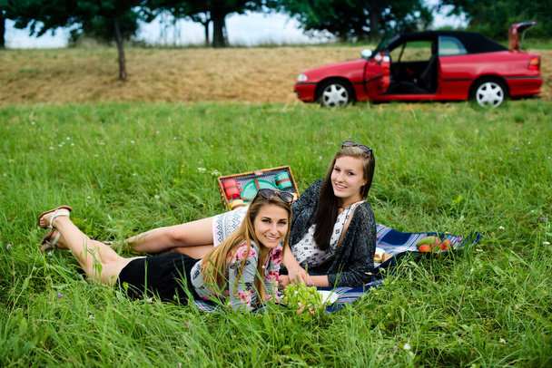 Best friends having a picnic next to their car - Фото, зображення