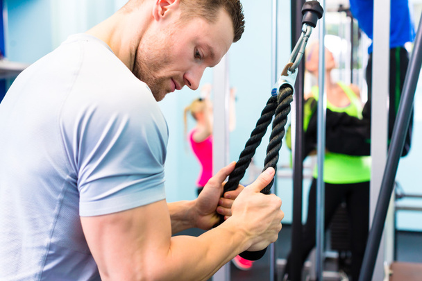 Entraînement d'homme en salle de gym avec appareil de fitness
 - Photo, image