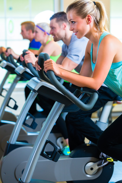 Group in gym spinning on sport bicycle - Photo, Image