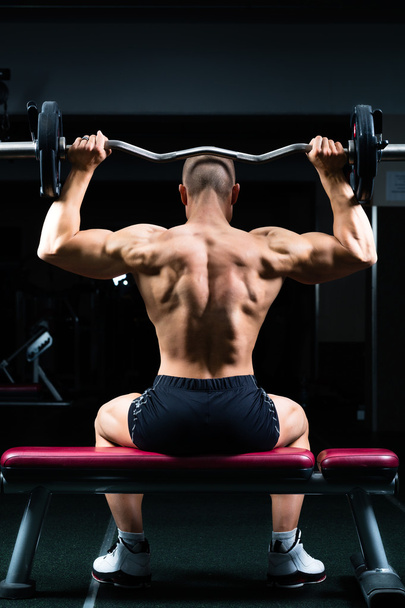Man in gym or fitness studio on weight bench - Photo, Image
