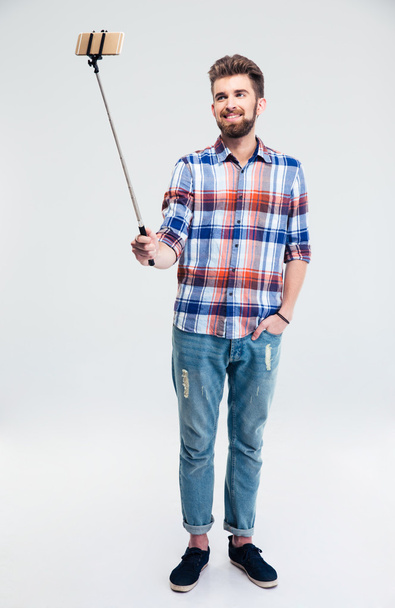 Smiling man making selfie photo with stick - Φωτογραφία, εικόνα