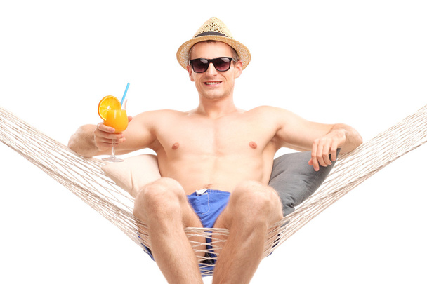 guy sitting in a hammock and drinking cocktail - Zdjęcie, obraz