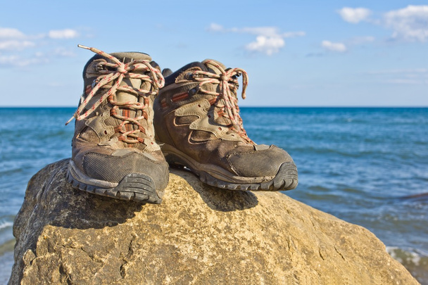 Pair of touristic boots on a sea coast - Zdjęcie, obraz