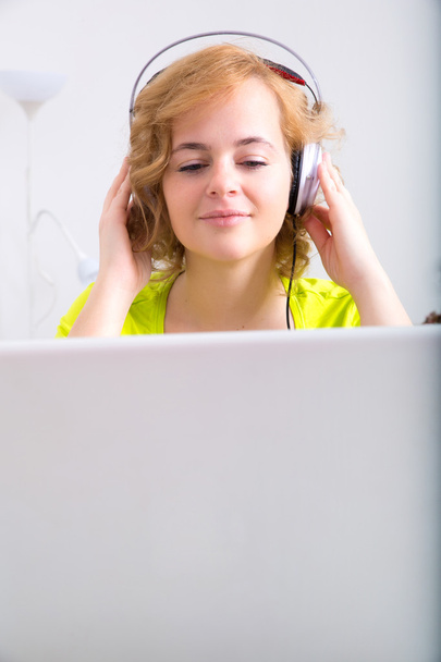 Portrait of a woman with headphones in front of a laptop compute - Fotografie, Obrázek
