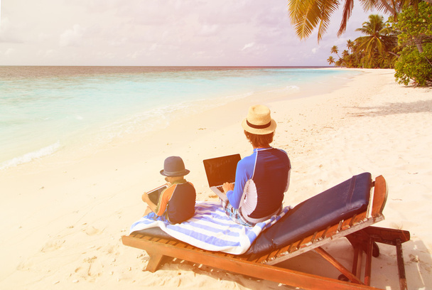 family with laptop and touch pad on beach - Photo, Image