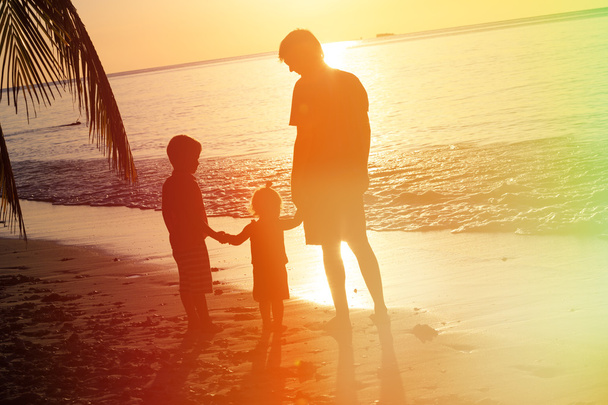 Vater und zwei Kinder bei Sonnenuntergang - Foto, Bild
