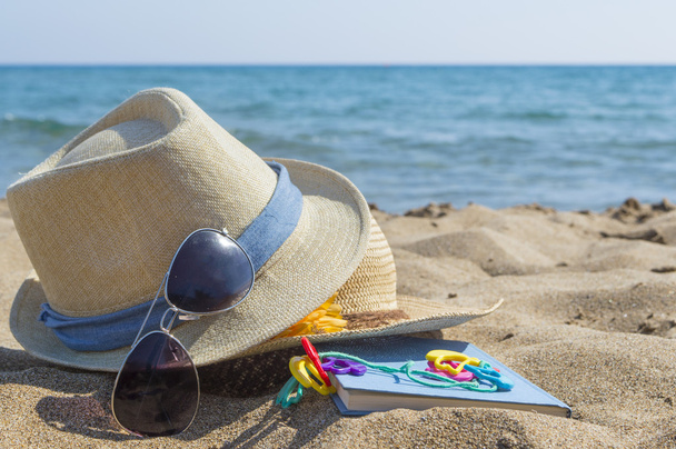 Соломенные шляпы, солнцезащитные очки и книга на пляже. Летний отдых
  - Фото, изображение
