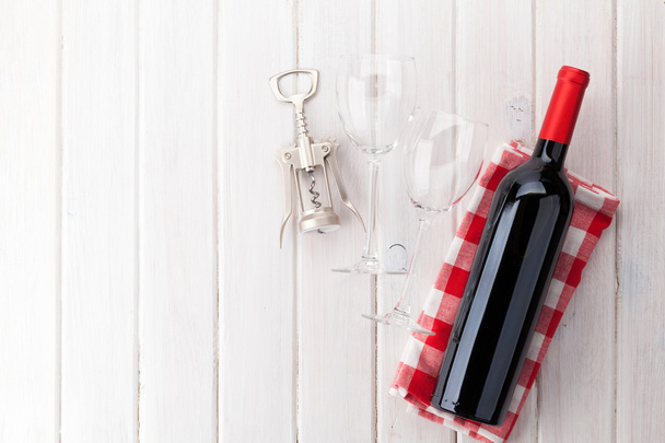 Red wine bottle, glasses and corkscrew - Fotó, kép