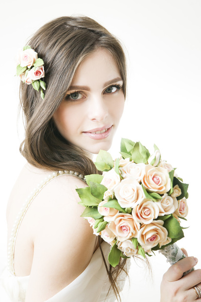 Studio portrait of a young beautiful bride with a bouquet - Photo, image