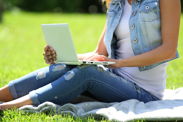Fiatal lány ül a fűben, laptop - Fotó, kép