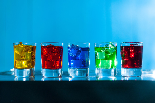 Cinq verres avec cocktail alcoolisé au bar de la boîte de nuit, fond bleu
 - Photo, image