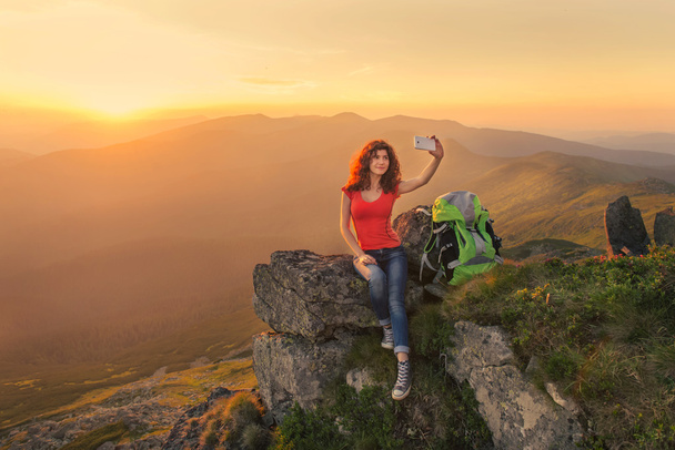 Женщина-турист фотографирует себя на вершине горы
 - Фото, изображение