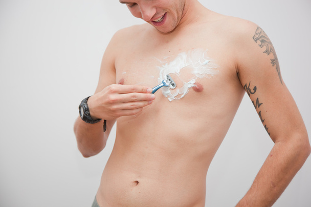 Молодой человек бреет грудь, туловище
 - Фото, изображение