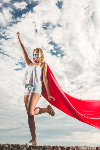 Jeune femme se faisant passer pour un super-héros sur un ciel bleu
 - Photo, image