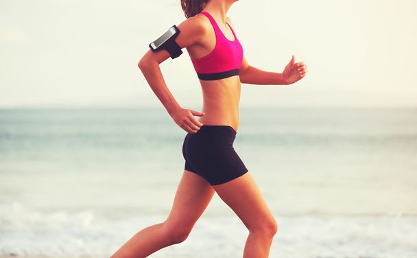 Mujer deportiva corriendo en la playa al atardecer
 - Foto, Imagen