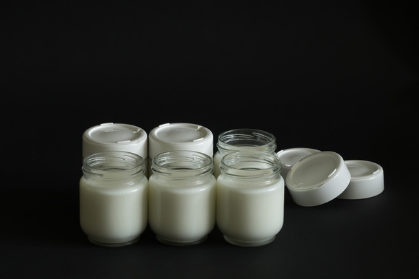 Six jars with milk - 写真・画像