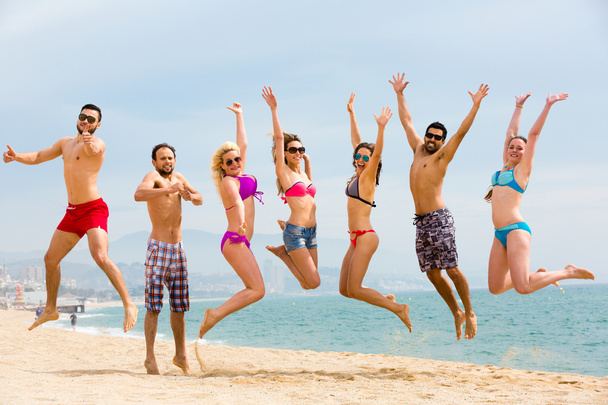 Щасливі туристи стрибають на пляжі
 - Фото, зображення