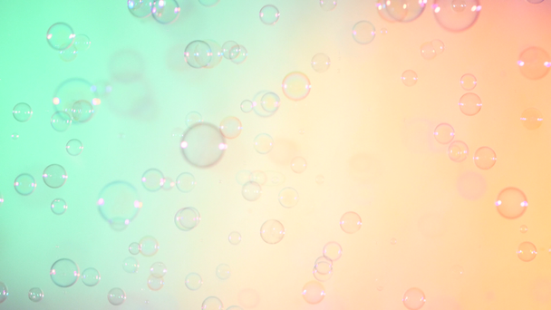 blaue und klare Seifenblasen auf türkis und rosa Hintergrund - Filmmaterial, Video
