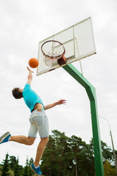 young man playing basketball outdoors - Foto, afbeelding