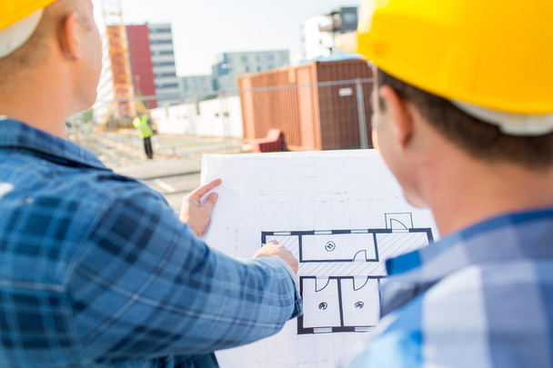 close up of builders with blueprint at building - Фото, зображення