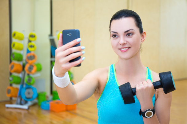 beautiful sporty woman making selfie photo with dumbbell on smar - Foto, Imagem