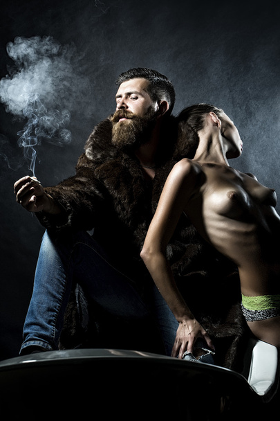 Smoking man and stripped woman - 写真・画像