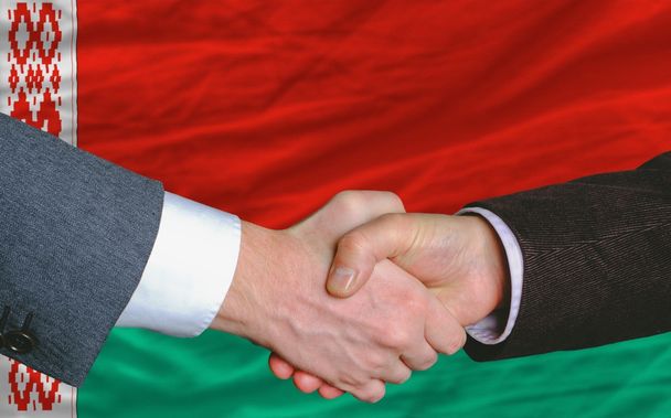 poignée de main des hommes d'affaires après une bonne affaire devant le drapeau de Belarus
 - Photo, image