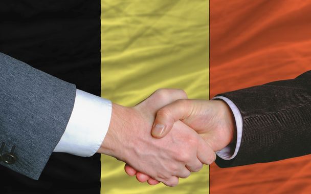 uomini d'affari stretta di mano dopo un buon affare di fronte alla bandiera belgio
 - Foto, immagini