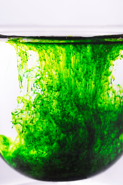 grüne Farbe im Glas Wasser verteilt  - Foto, Bild
