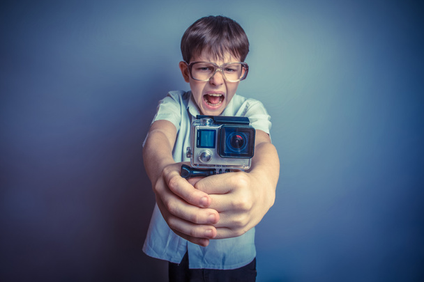 ein etwa zehnjähriger Junge von europäischem Aussehen in hellbraunem Hemd und  - Foto, Bild
