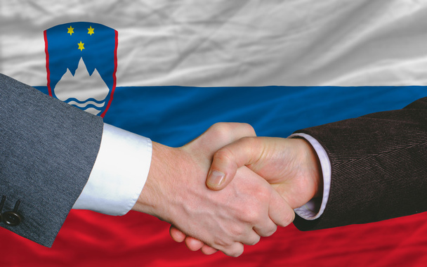 Businessmen handshake after good deal in front of slovenia flag - Photo, Image
