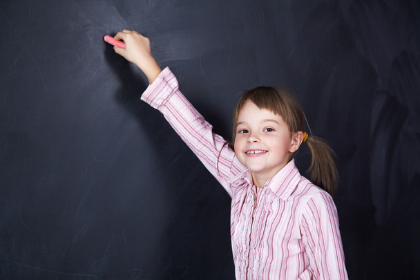 schoolchild on blackboard background - Fotó, kép