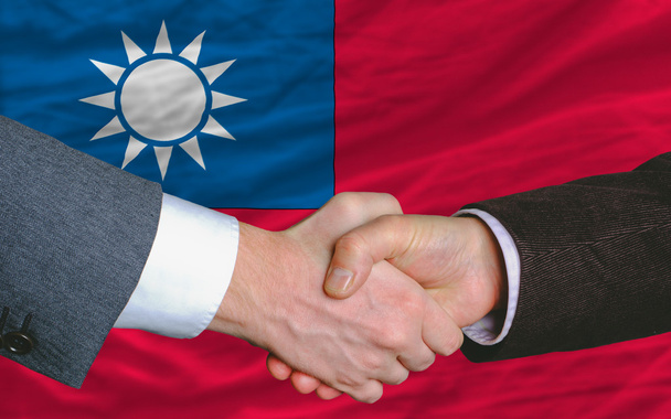 Empresarios apretón de manos después de un buen trato frente a la bandera de Taiwán
 - Foto, Imagen