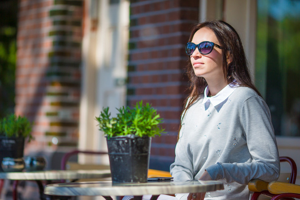 Gyönyörű nő ül a szabadban kávézóban európai város  - Fotó, kép