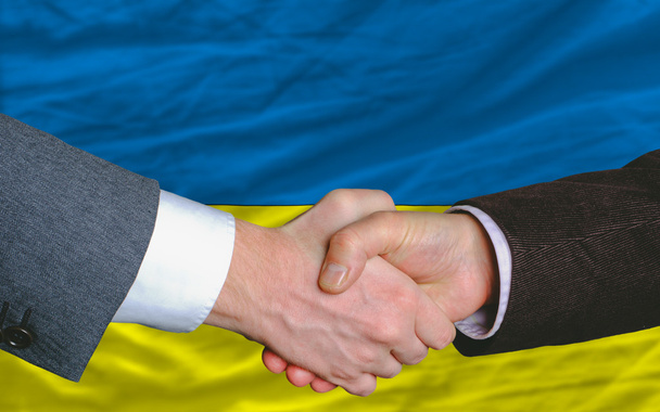 Uomini d'affari stretta di mano dopo un buon affare di fronte alla bandiera ucraina
 - Foto, immagini