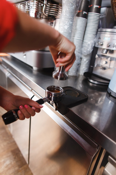 Barista using a tamper to press ground coffee - Zdjęcie, obraz