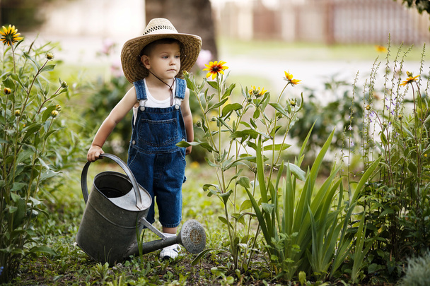 little boy with watering can in summer park - Fotografie, Obrázek