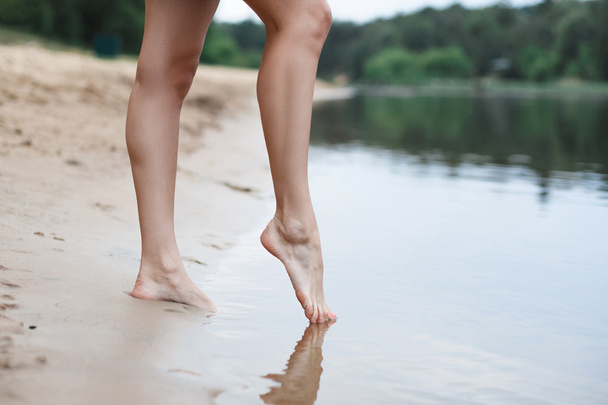 Belas pernas femininas entram na água
 - Foto, Imagem