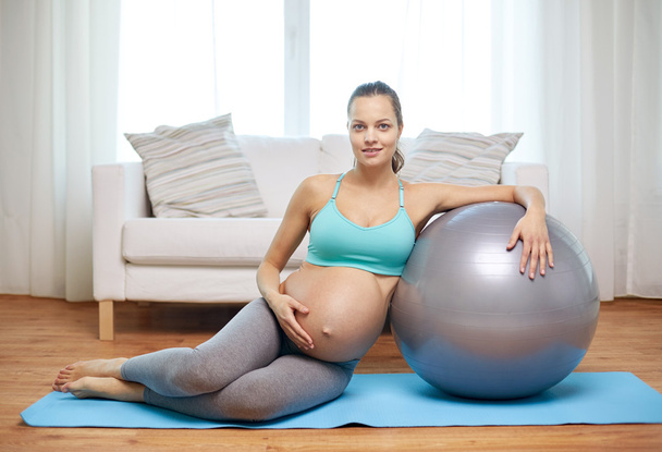 happy pregnant woman with fitball at home - Foto, afbeelding