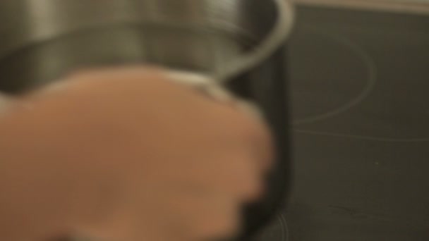 Γυναίκα που βάζουμε με τη κατσαρόλα του νερού στη σόμπα κουζίνα - Πλάνα, βίντεο