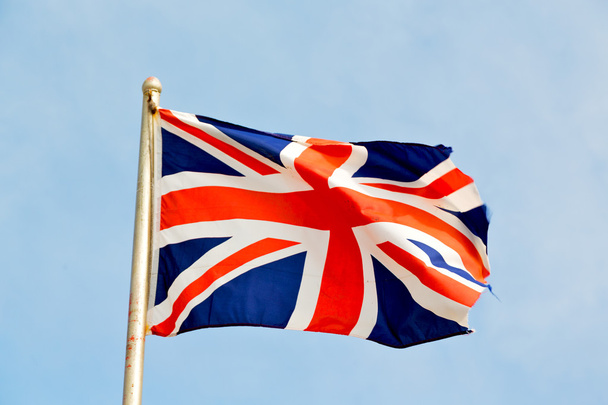 acenando bandeira no céu azul britânico
  - Foto, Imagem