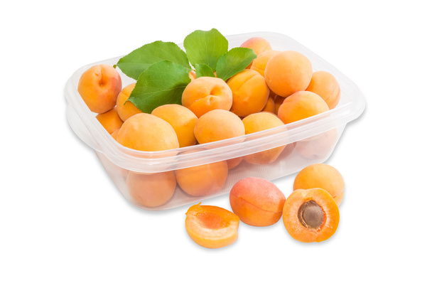 Rijp abrikozen in kunststof lade en verschillende abrikozen afzonderlijk cl - Foto, afbeelding