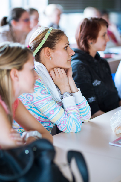 Молодая, красивая студентка колледжа, сидящая в классе
 - Фото, изображение