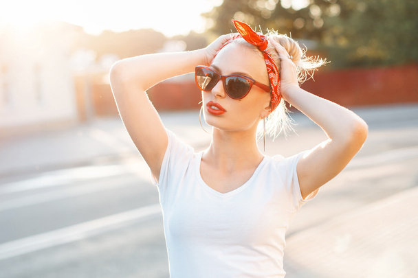 Hermosa mujer hipster con labios rojos y gafas de sol de pie
 - Foto, imagen